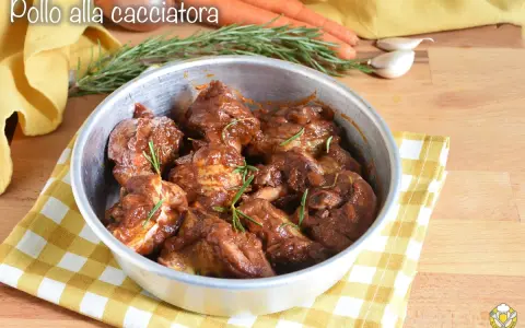 Succulento pollo alla cacciatora in padella, con rosmarino fresco e contorni di carote e aglio.