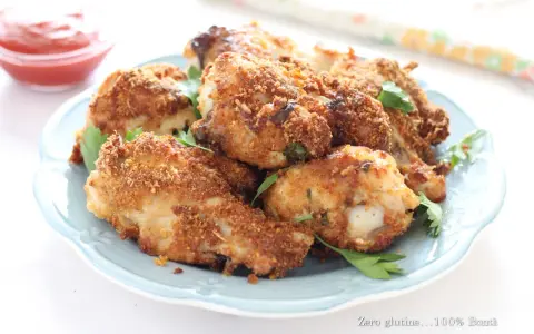 Alette di pollo croccanti in friggitrice ad aria, servite su un piatto azzurro con prezzemolo fresco e una ciotolina di ketchup.