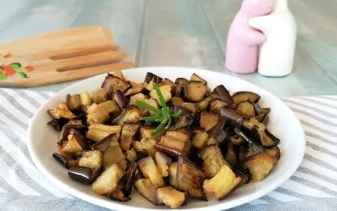 Melanzane in friggitrice ad aria, dorate e saporite, pronte per essere gustate. Un rametto di rosmarino le impreziosisce.