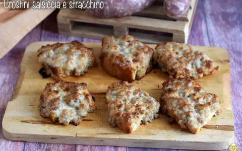 Sei crostini salsiccia e stracchino dorati e filanti, pronti per essere gustati.