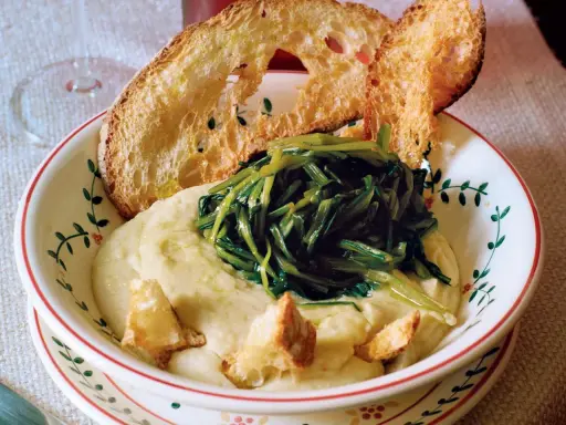Piatto di fave e cicoria con crostini di pane abbrustolito.