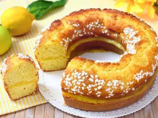 Torta al limone morbidissima e profumatissima benedetta, con ripieno cremoso e decorata con perle di zucchero.
