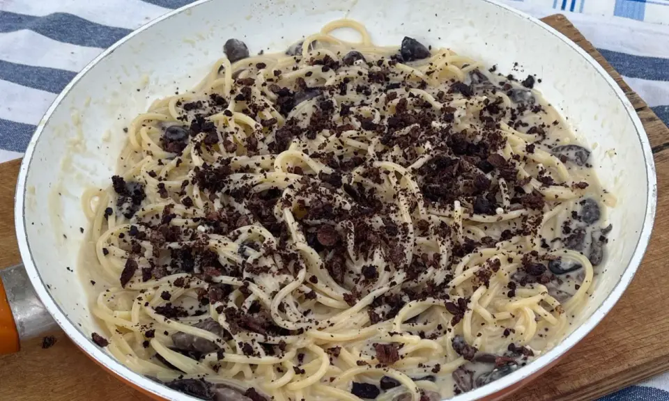 Spaghetti cremosi con olive nere e una spolverata di cacao amaro, un'originale pasta alla cenere.