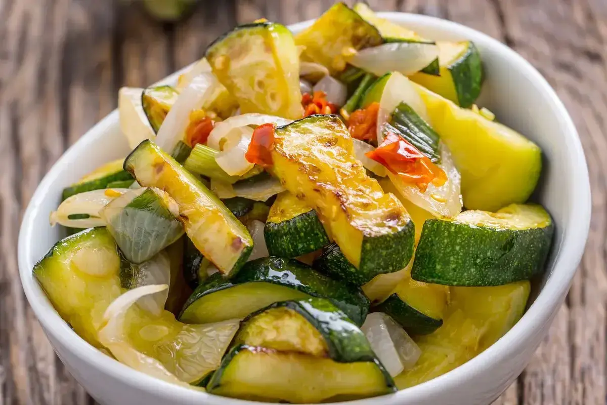 Zucchine in padella, dorate e saporite, con cipolla e peperoncino. Un contorno leggero e gustoso.