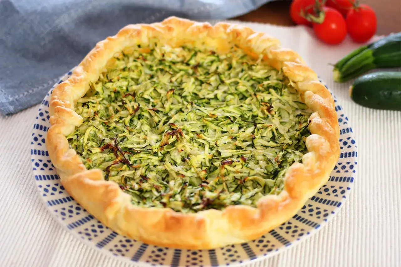 Torta salata con zucchine grattugiate e ricotta, con bordo dorato e croccante. Perfetta per un pranzo leggero.