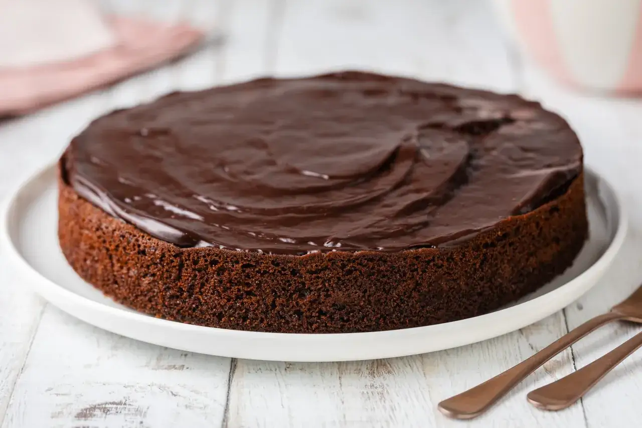 Una deliziosa torta al cioccolato con glassa lucida, pronta per essere gustata.