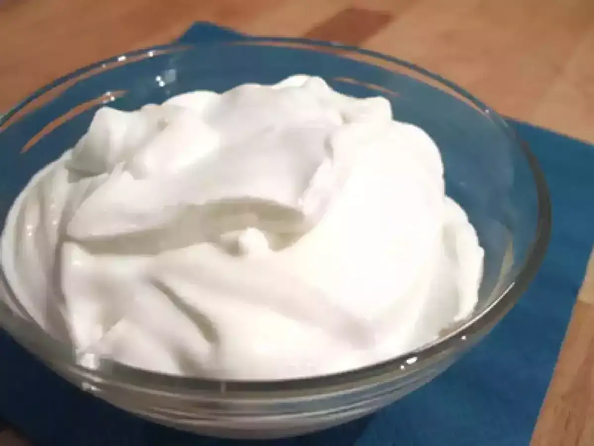 Panna acida ricetta: una ciotola di vetro piena di panna acida fatta in casa, cremosa e soffice, pronta per essere gustata.