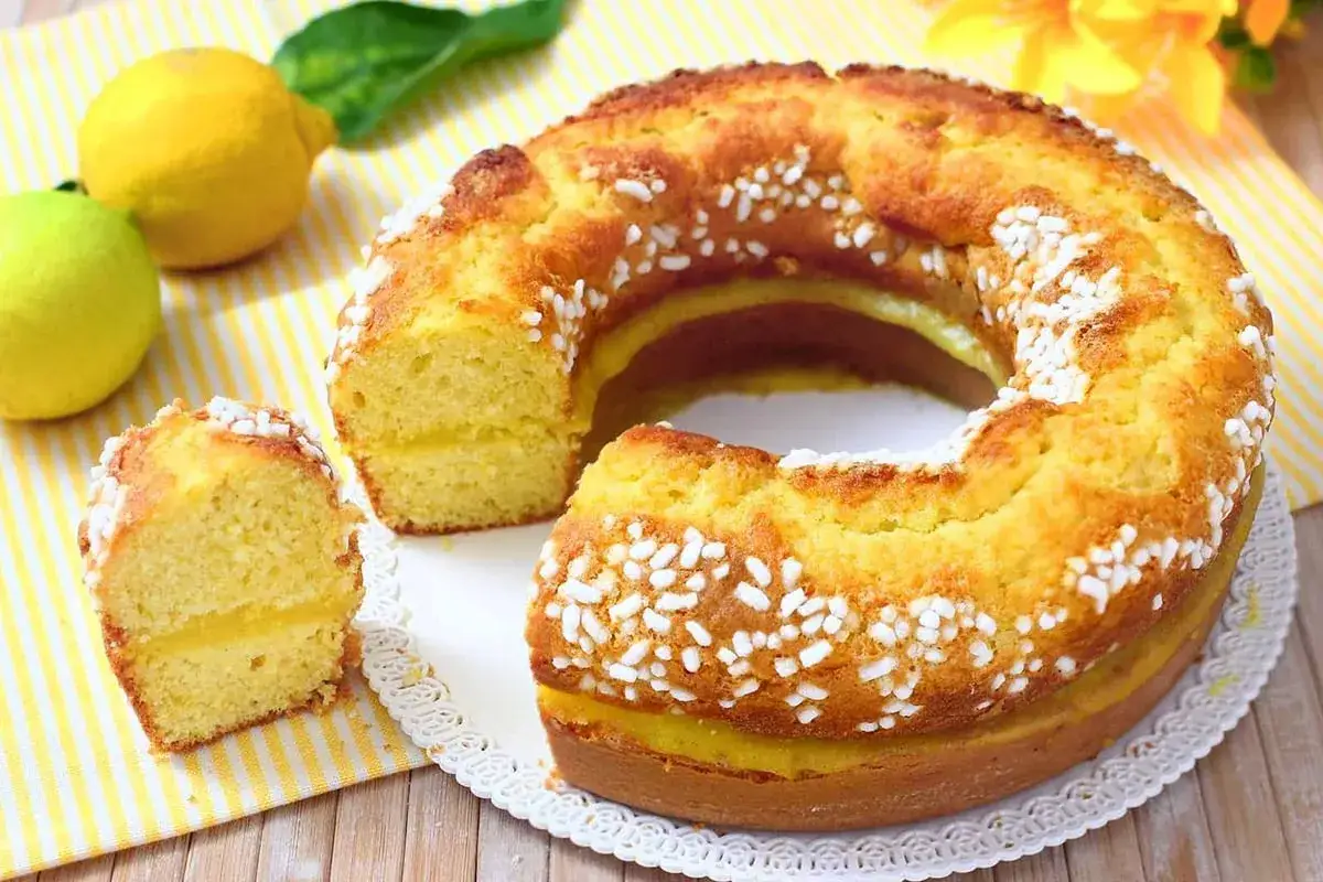 Torta al limone morbidissima e profumatissima, un dolce benedetto con ripieno cremoso e decorazione di perline di zucchero.
