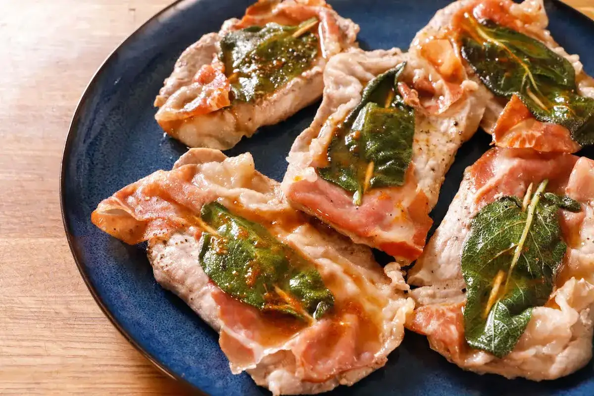 Saltimbocca alla romana ricetta originale: fettine di vitello con prosciutto e salvia, cotte in padella con un sughetto dorato.