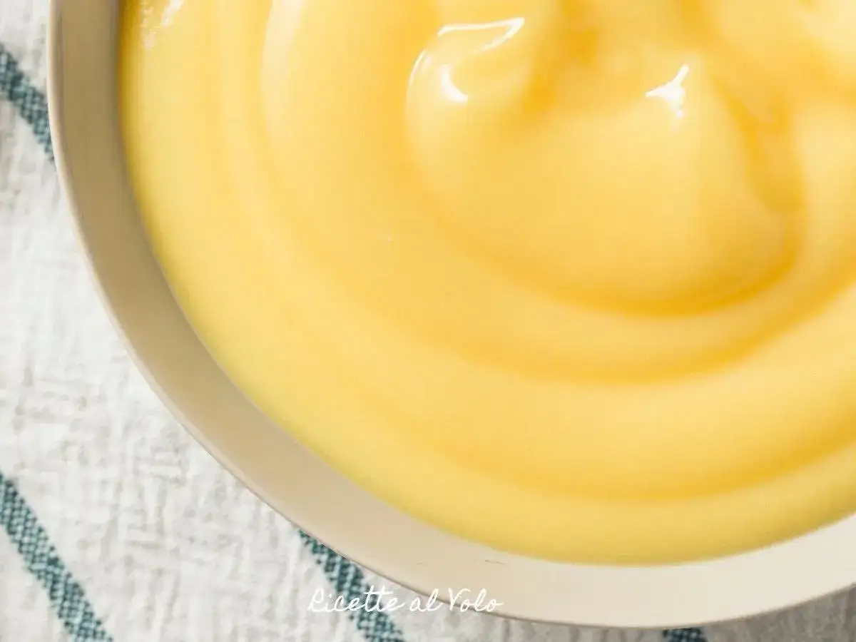 Una ciotola piena di soffice crema al latte, con onde lisce e lucide che invitano ad essere gustate.