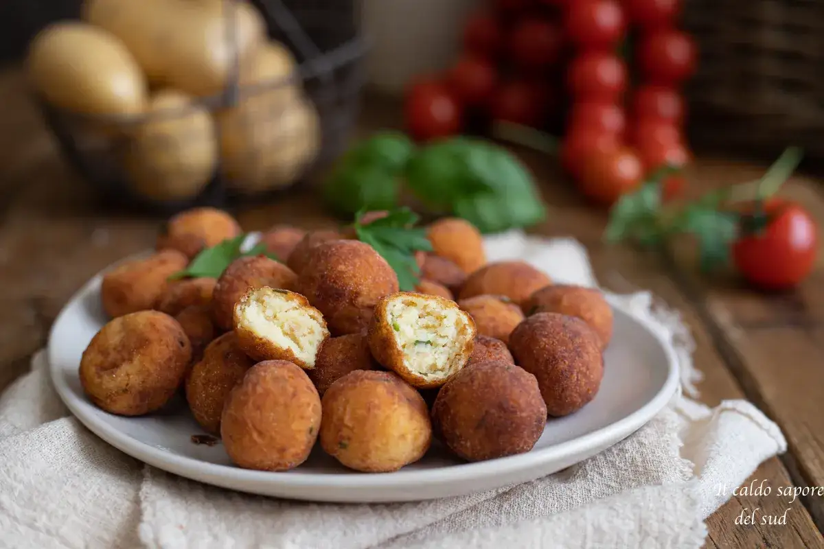 Crocchette di patate dorate e fragranti, una delizia fatta in casa. Sullo sfondo, pomodorini e patate fresche.