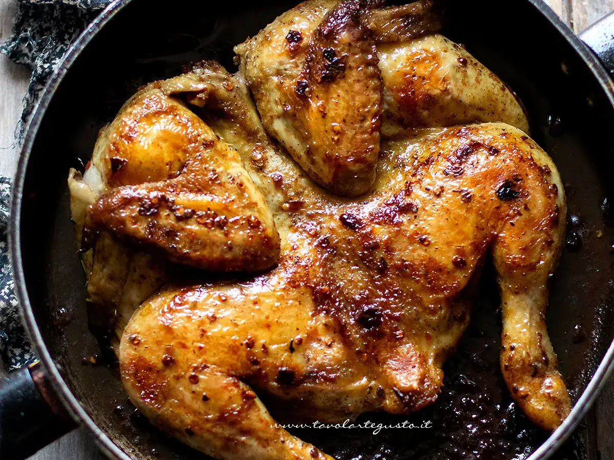 Pollo alla diavola dorato e succulento, cotto in padella con spezie piccanti.