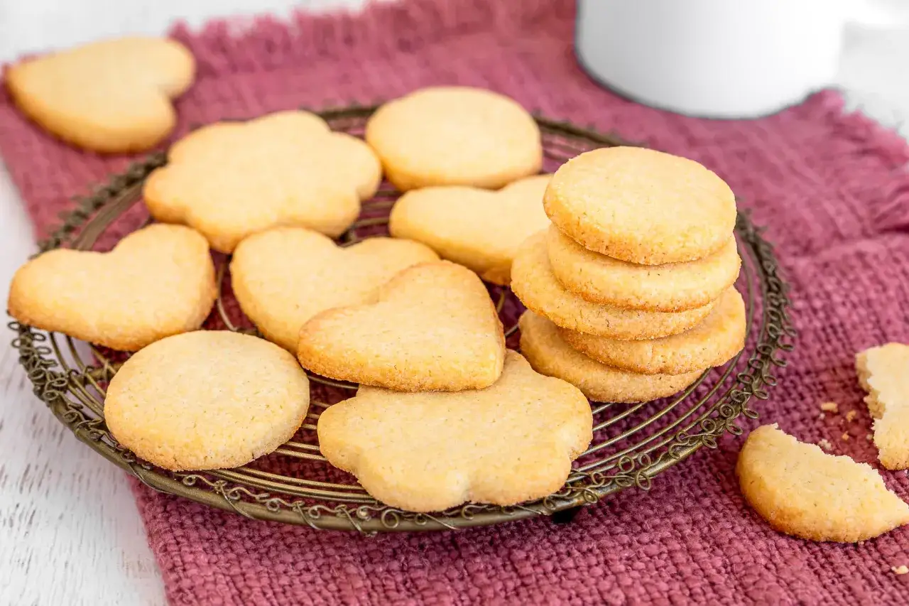 Biscotti fatti in casa a forma di cuore e fiore, perfetti per un t&egrave; pomeridiano.