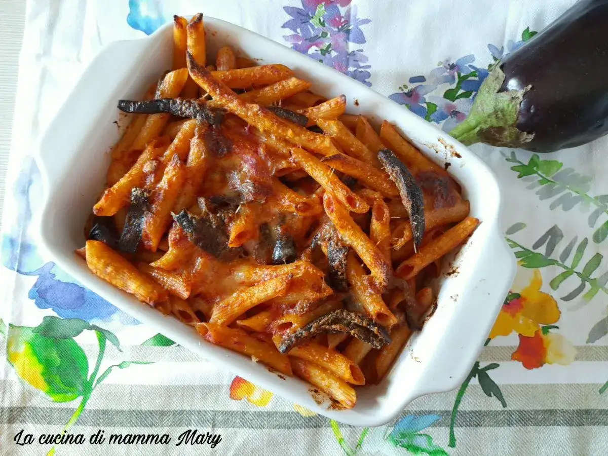 Penne al forno con melanzane, un classico della cucina italiana, cotte alla perfezione con formaggio filante e un tocco di pomodoro.
