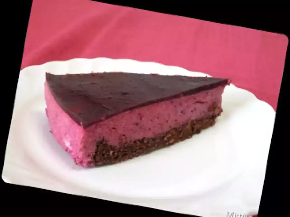 Una fetta di bavarese al cioccolato con copertura lucida e base croccante, servita su un piatto bianco.