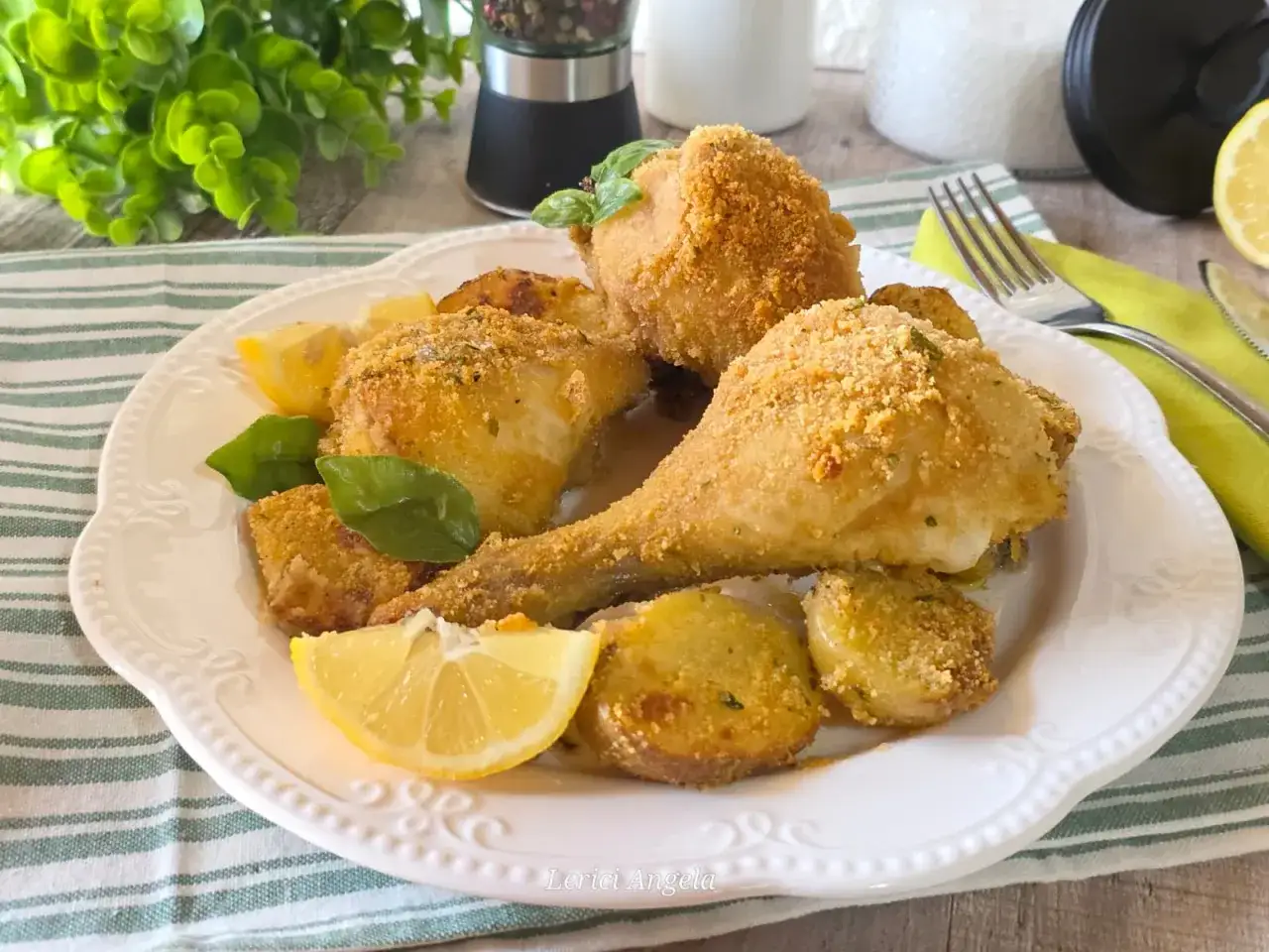Fusi di pollo dorati e croccanti, serviti con patate arrosto e spicchi di limone fresco. Un piatto invitante e saporito.