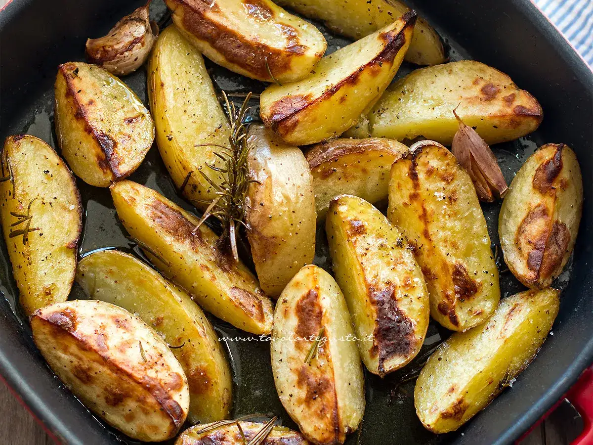 Patate al forno croccanti, dorate e profumate al rosmarino e aglio, pronte per essere gustate.