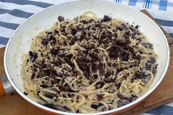 Spaghetti cremosi con olive nere e una spolverata di cacao amaro, un'originale pasta alla cenere.