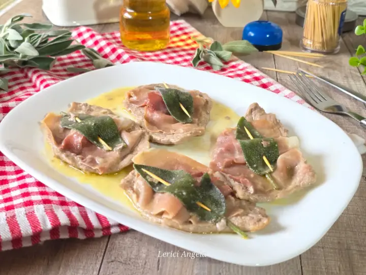 Saltimbocca alla romana: fettine di vitello con prosciutto e salvia, servite su un piatto bianco con salsa dorata.