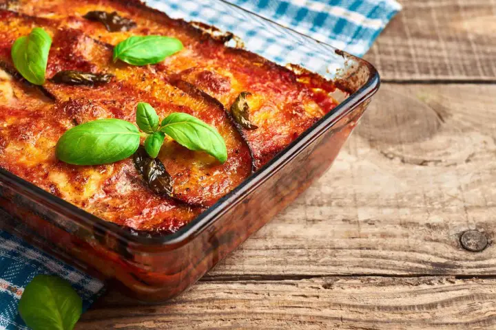Parmigiana di melanzane in friggitrice ad aria, dorata e profumata, guarnita con basilico fresco. Un classico rivisitato per un risultato leggero e gustoso.